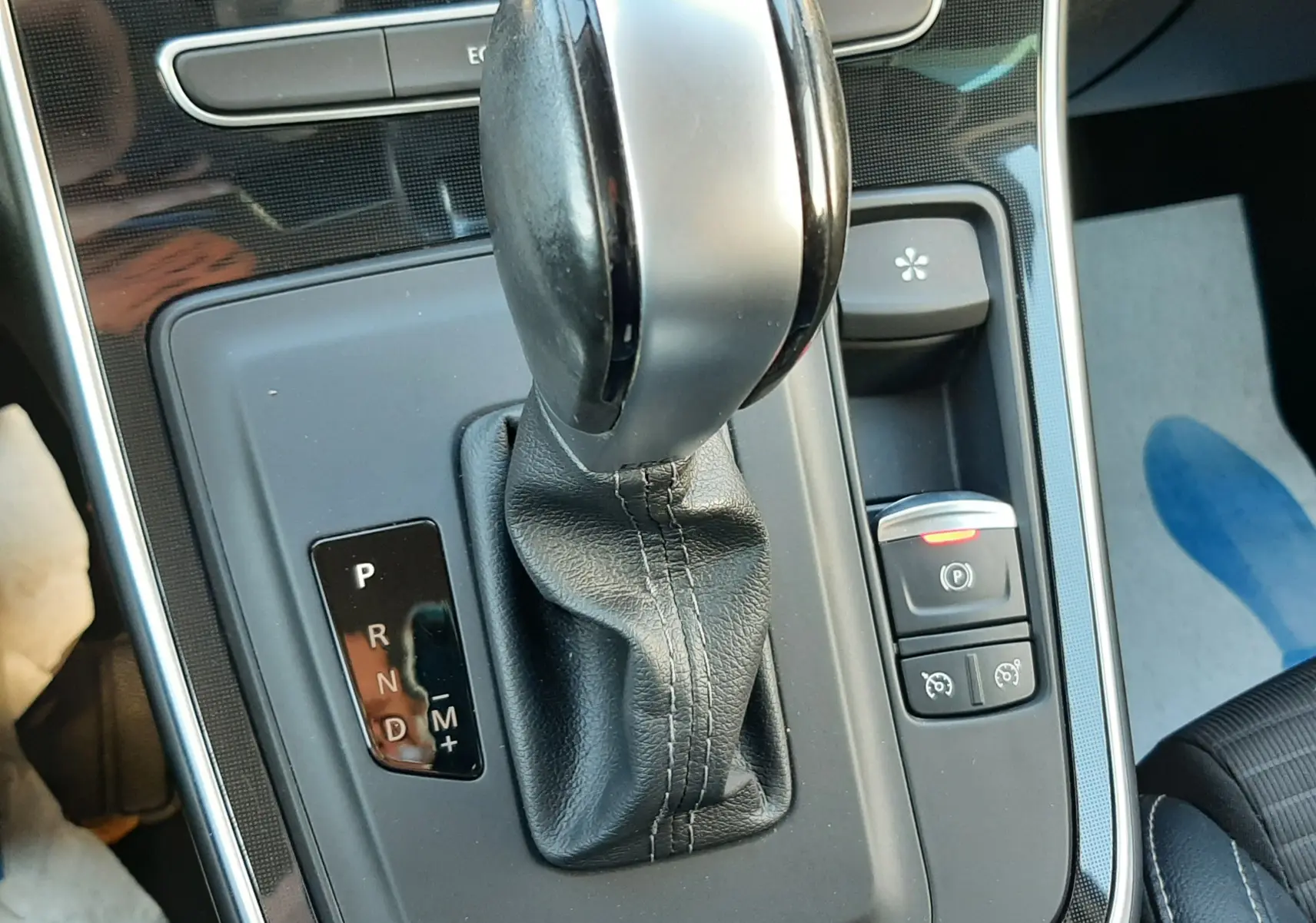 Le levier de vitesse automatique en cuir noir et chrome du Renault Scenic IV, vue rapprochée de la console centrale.