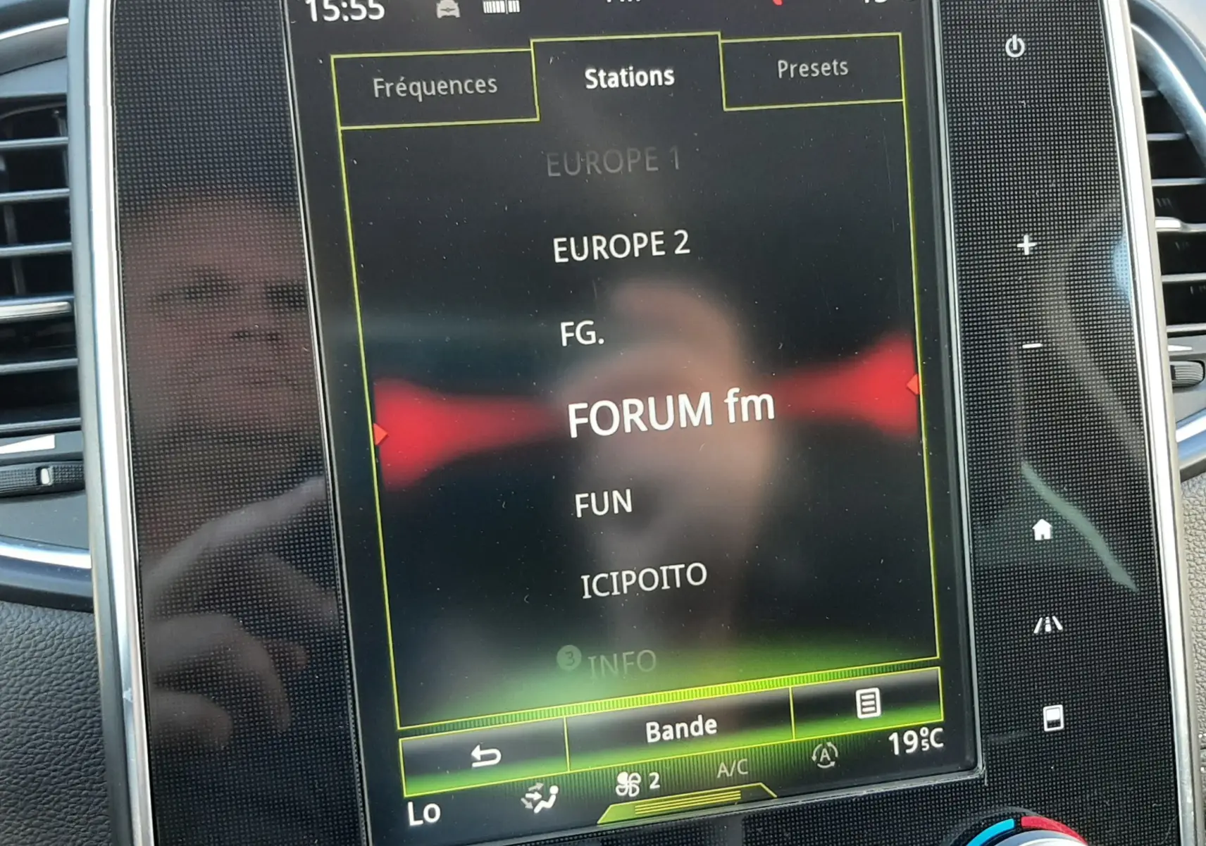 Écran tactile central du Renault Scénic IV affichant les stations radio FM avec commandes climatisation en dessous.