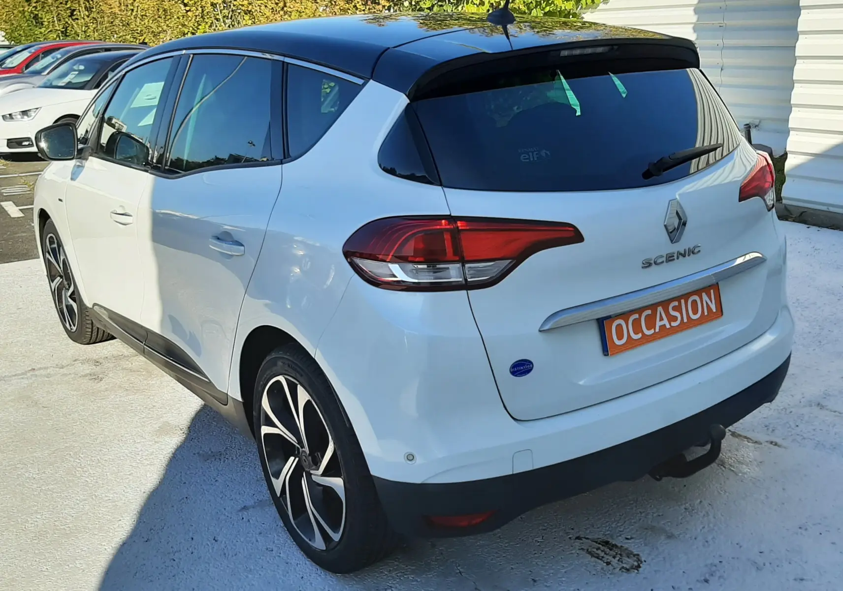 Vue 3/4 arrière droite du Renault Scénic IV blanc nacré avec toit noir et jantes alliage distinctives.
