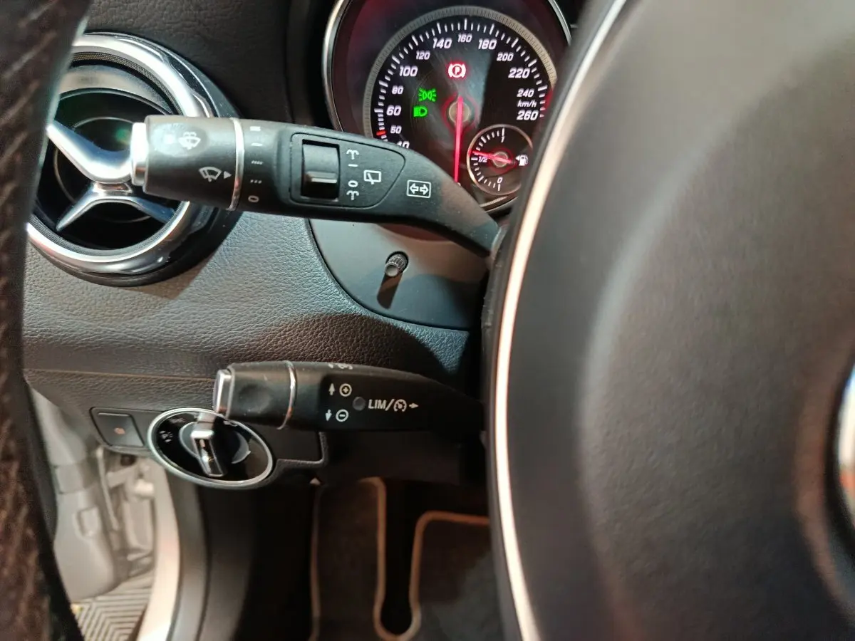 Vue rapprochée du volant cuir et des commandes au volant du Mercedes GLA 200 d gris clair, tableau de bord éclairé.