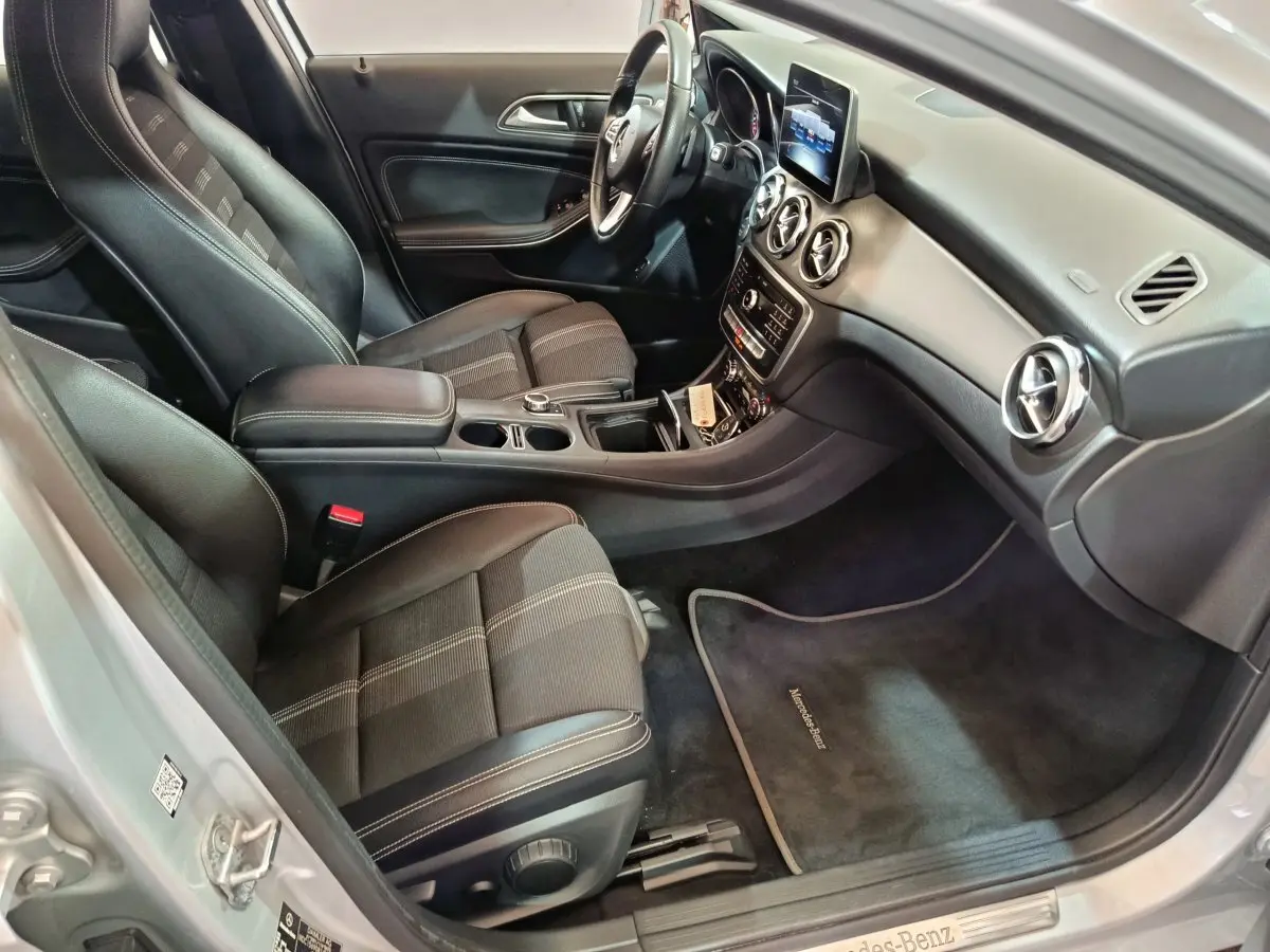 Vue intérieure côté passager du Mercedes GLA 200 d gris clair, avec sièges tissu noir et tableau de bord moderne.