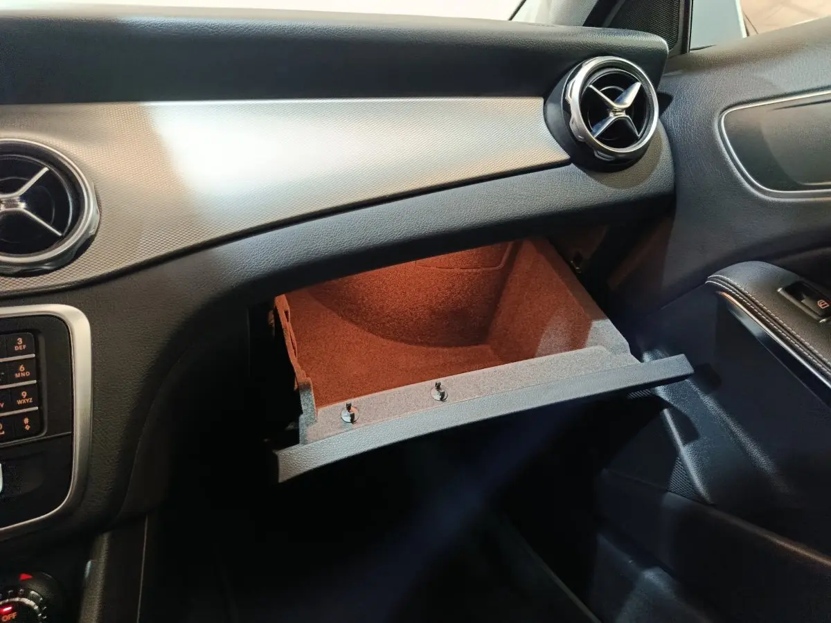 Intérieur du Mercedes GLA 200 d 2018 côté passager, boîte à gants ouverte avec aérateurs ronds chromés visibles.
