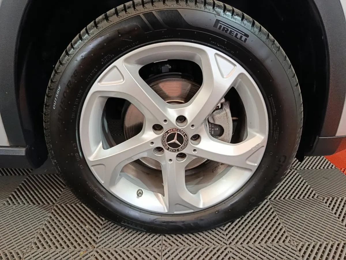 Gros plan sur la roue avant droite d'un Mercedes GLA 200 d gris clair avec jante alliage cinq branches et pneu Pirelli.