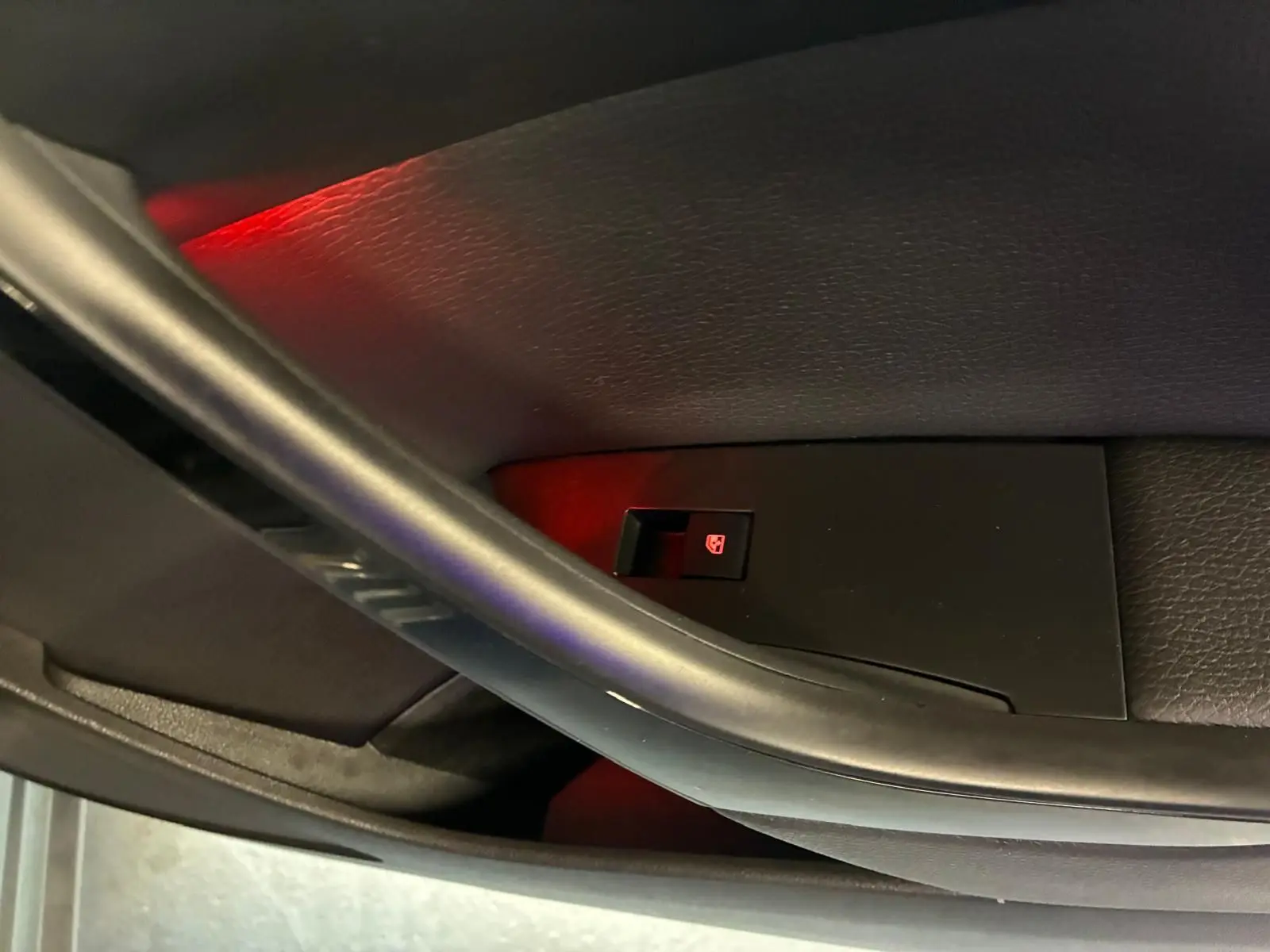 Détail de la commande de lève-vitre électrique sur la porte intérieure côté conducteur d'une Opel Astra gris 2015.