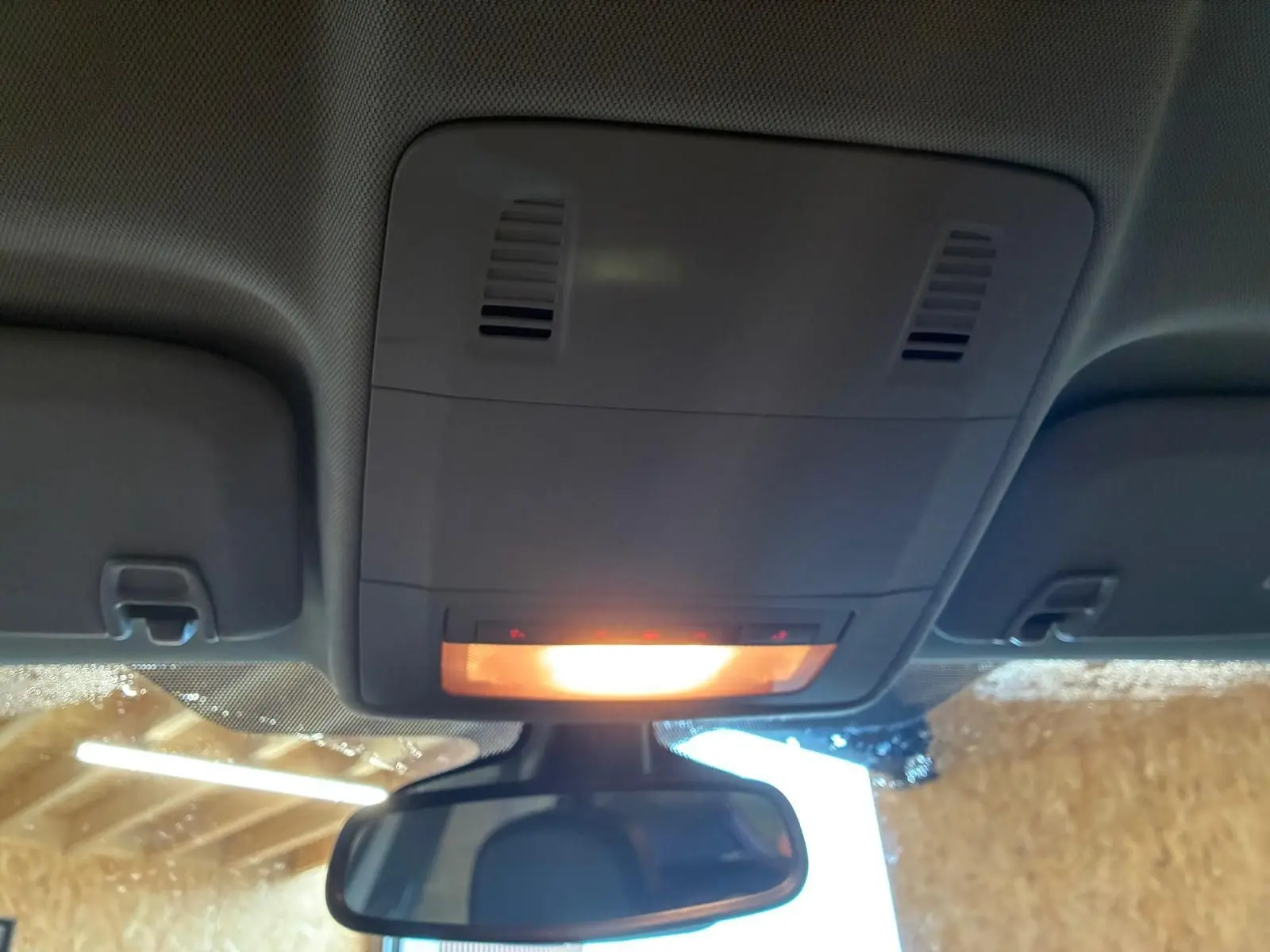 Vue intérieure du plafonnier allumé et du rétroviseur central d'une Opel Astra gris 2015.