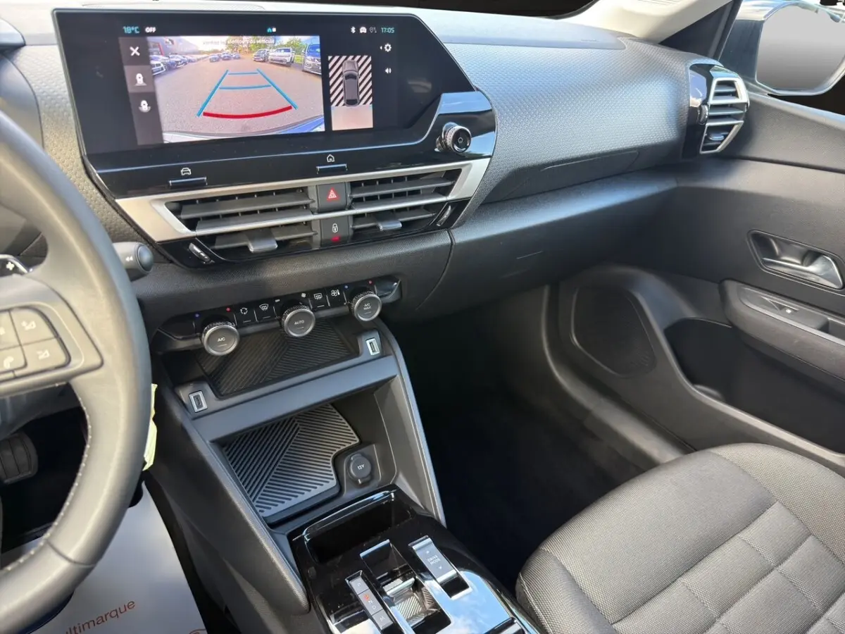 Vue intérieure côté passager de la Citroën C4 hybride 2025, avec écran tactile central affichant la caméra de recul.