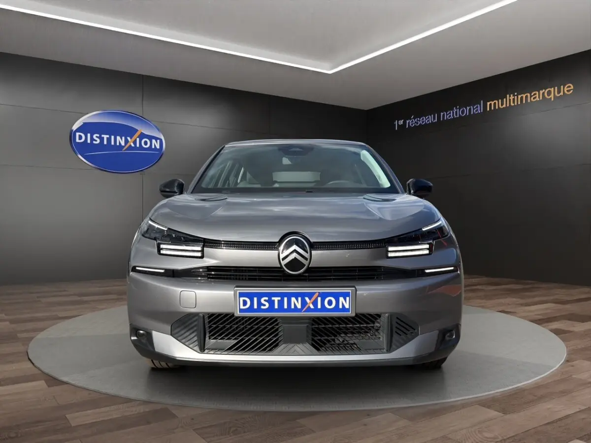 Vue frontale d'une Citroën C4 hybride gris foncé, avec phares LED distinctifs et calandre moderne.