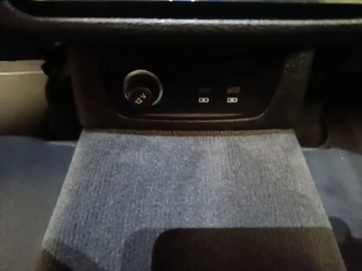 Prise 12V et ports USB arrière sur console centrale, intérieur sombre de l'Audi Q3 Sportback gris clair 2024.
