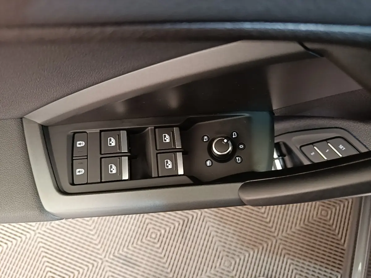 Commande des vitres et réglage des rétroviseurs côté gauche dans l'habitacle gris foncé de l'Audi Q3 Sportback 2024.