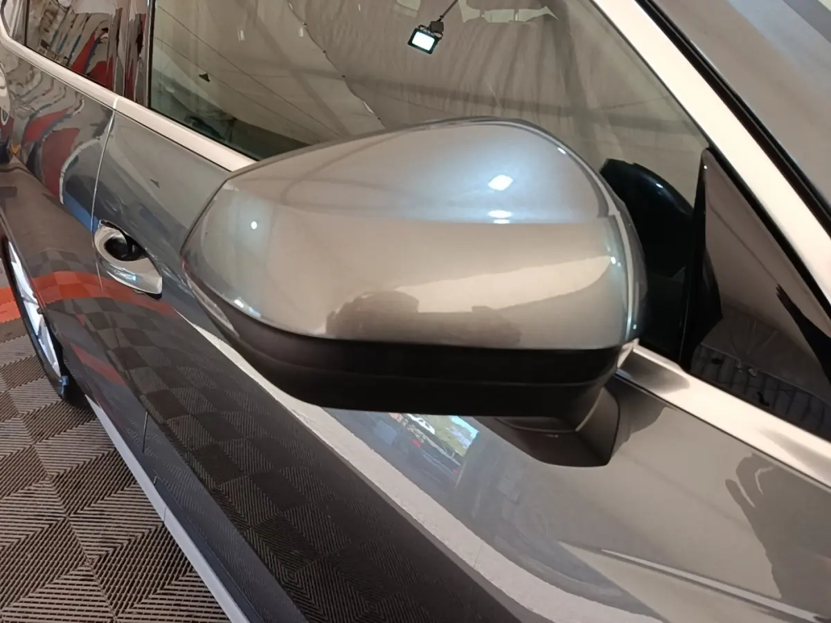 Rétroviseur droit gris clair de l’Audi Q3 Sportback 2024, vue rapprochée sur la portière et la poignée.