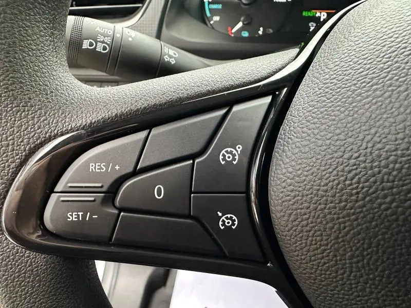 Gros plan sur les commandes de régulateur de vitesse au volant noir du Nissan Townstar électrique gris 2024.