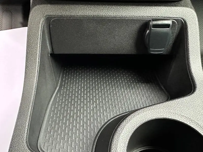 Gros plan sur le rangement central noir texturé avec prise 12V dans le Nissan Townstar électrique gris 2024