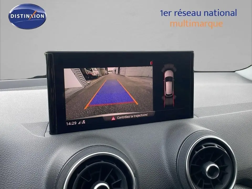 Écran central affichant la caméra de recul et l'aide au stationnement du tableau de bord d'un Audi Q2 noir Mito Metal 2023.