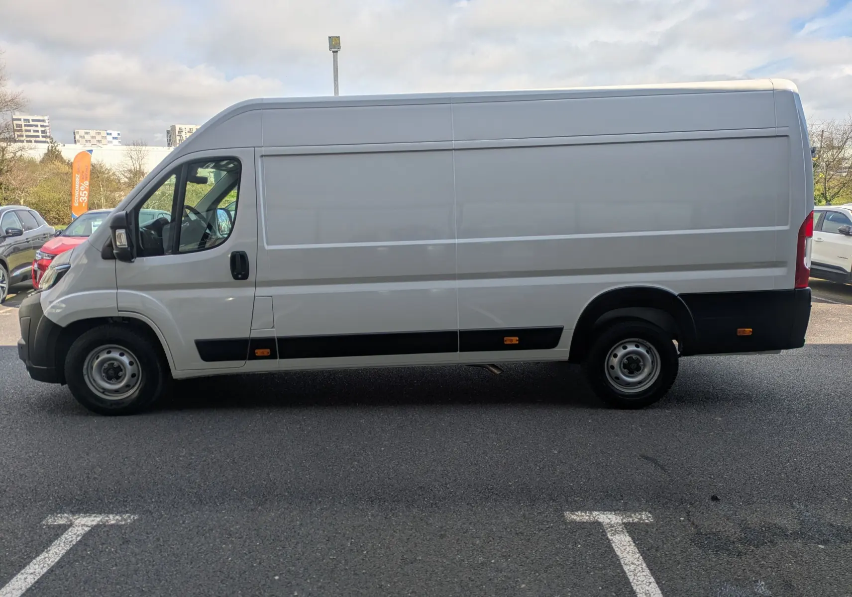 Vue latérale droite d’un Peugeot Boxer Fourgon blanc, version L4H2, avec portes coulissantes et jantes acier 16 pouces.