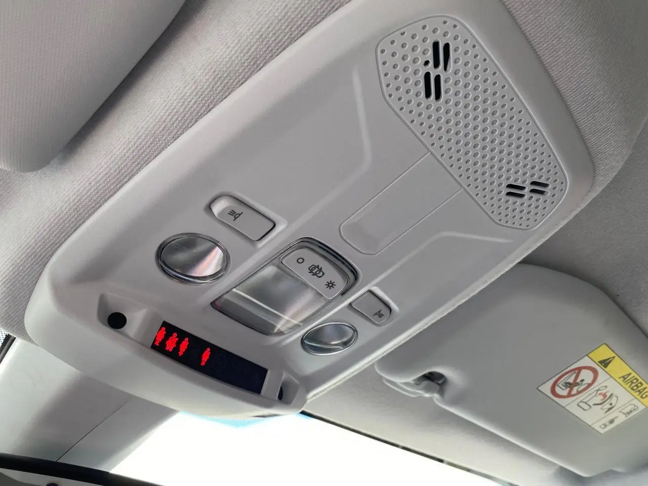 Vue en contre-plongée du plafonnier gris clair de l'Opel Corsa 2021 avec commandes d'éclairage et haut-parleur intégré.