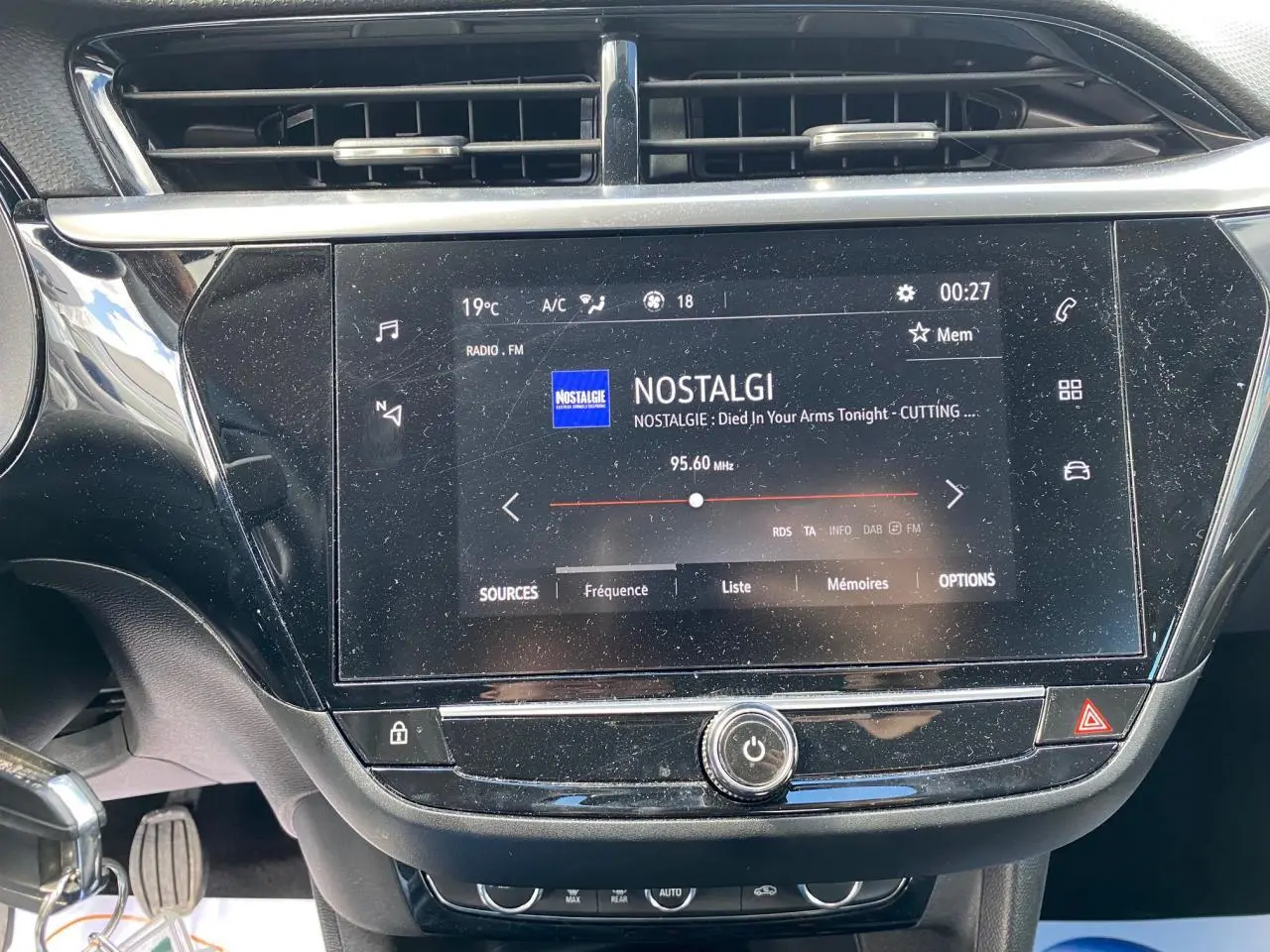 Écran tactile central allumé affichant la radio FM dans l'habitacle noir d'une Opel Corsa 1.2i Turbo 2021.