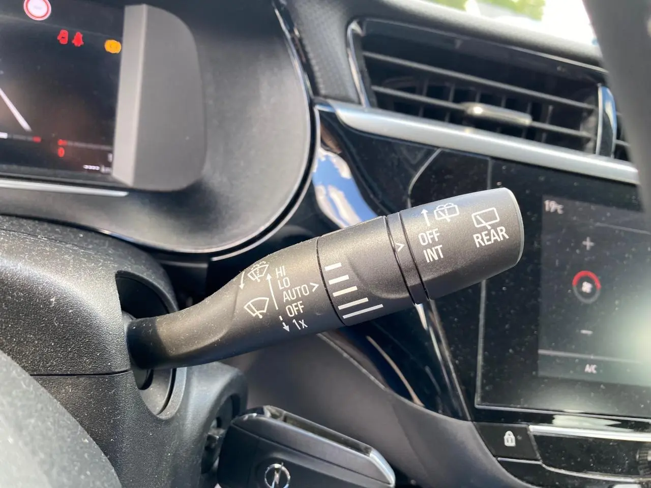 Le commodo d'essuie-glace en gros plan dans l'habitacle noir de l'Opel Corsa bleu nautique 2021.