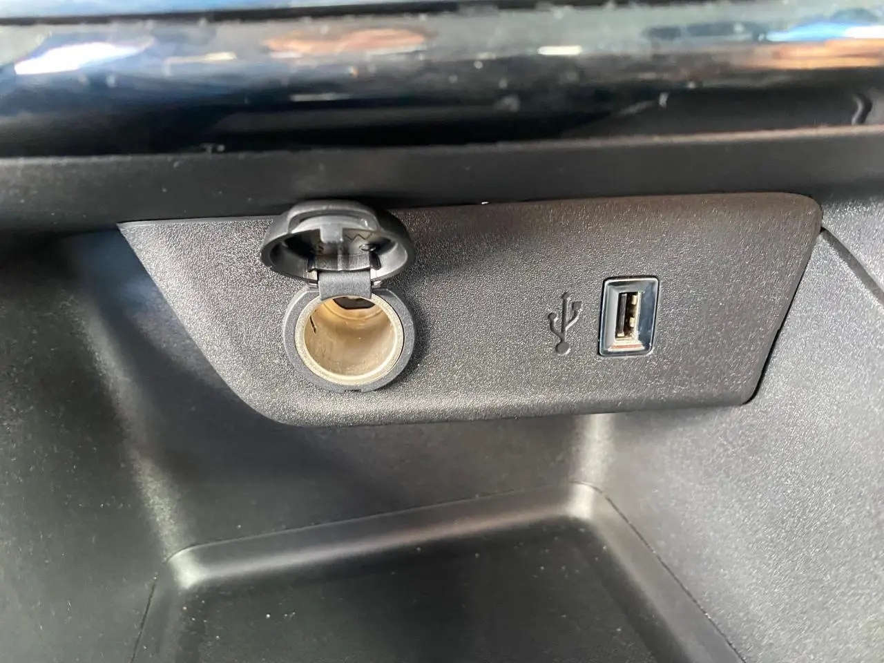 Prise 12V et port USB type-A intégrés dans la console centrale de l'Opel Corsa 1.2i Turbo bleu nautique.