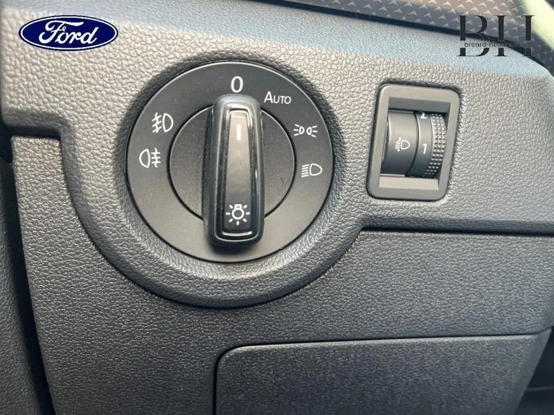 Gros plan sur le bouton de commande des phares et réglage d'intensité dans un Volkswagen T-cross gris cendré 2022