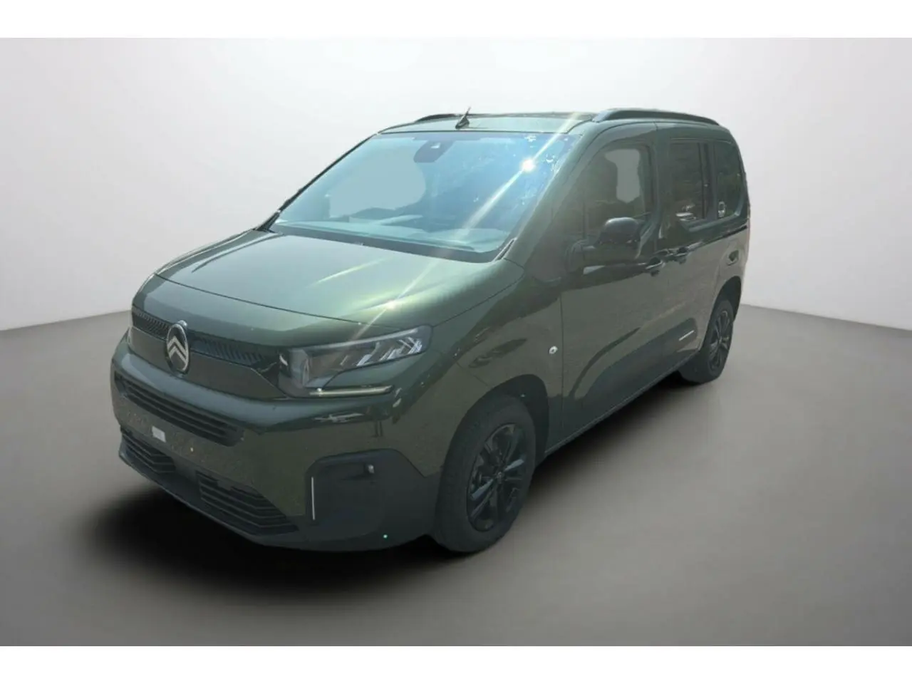 Vue 3/4 avant du Citroën Berlingo 2025 en vert Sirka métallisé avec jantes alliage noires et calandre marquée.