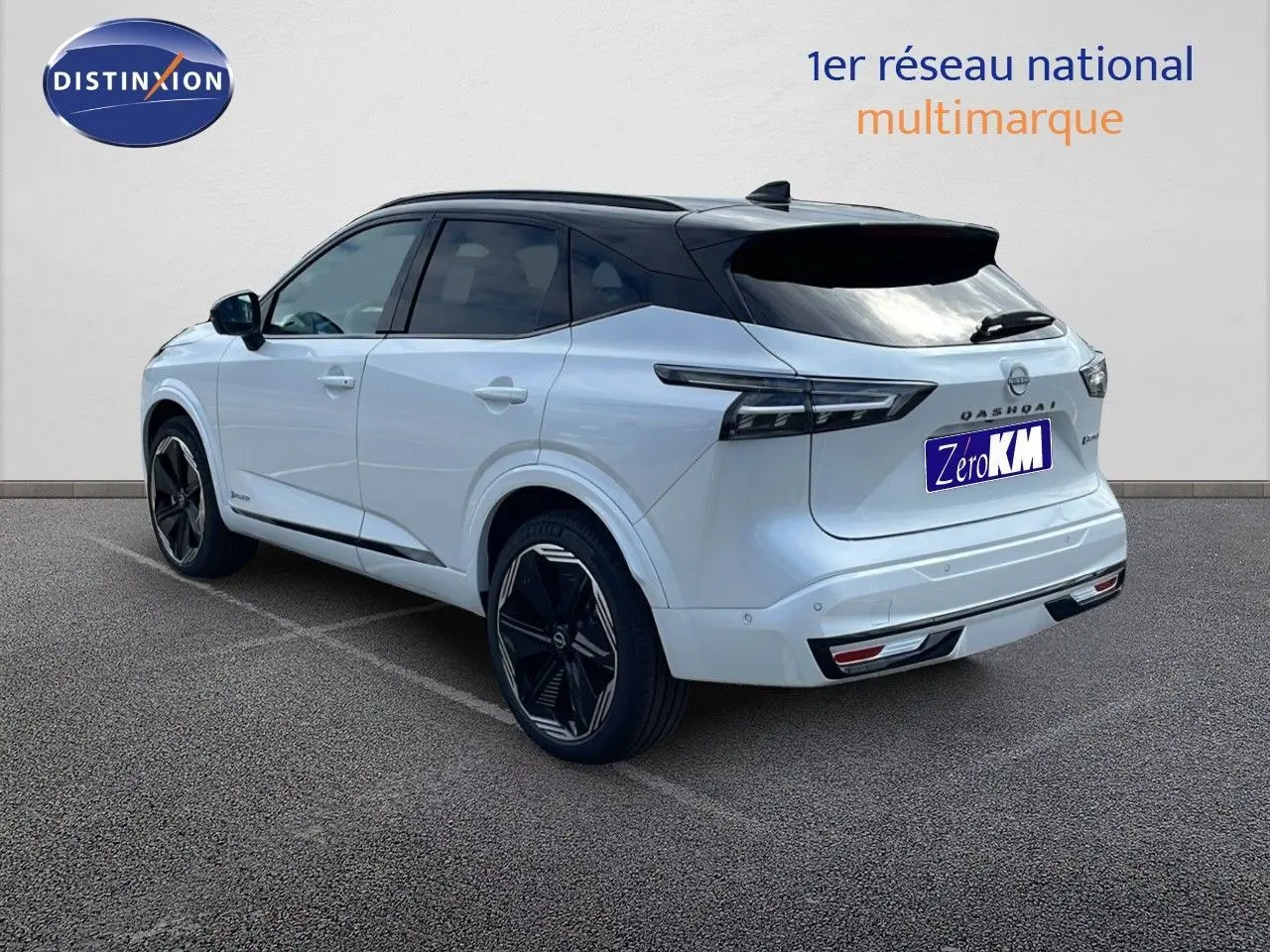 Vue 3/4 arrière droite du Nissan Qashqai blanc nacré avec toit noir, jantes noires et feux arrière LED distinctifs.