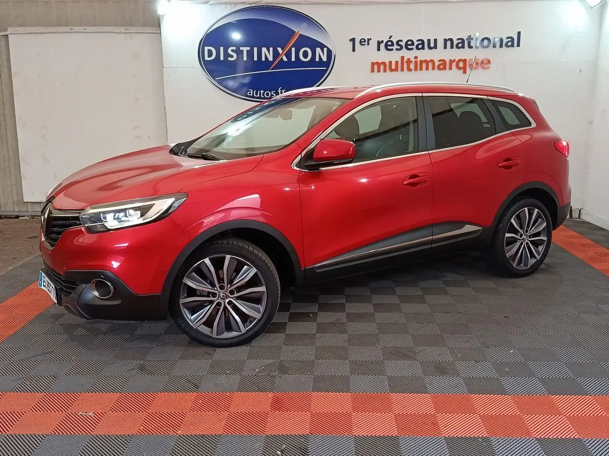 Renault Kadjar rouge vue de profil côté gauche dans un showroom avec jantes alliage et feux allumés.
