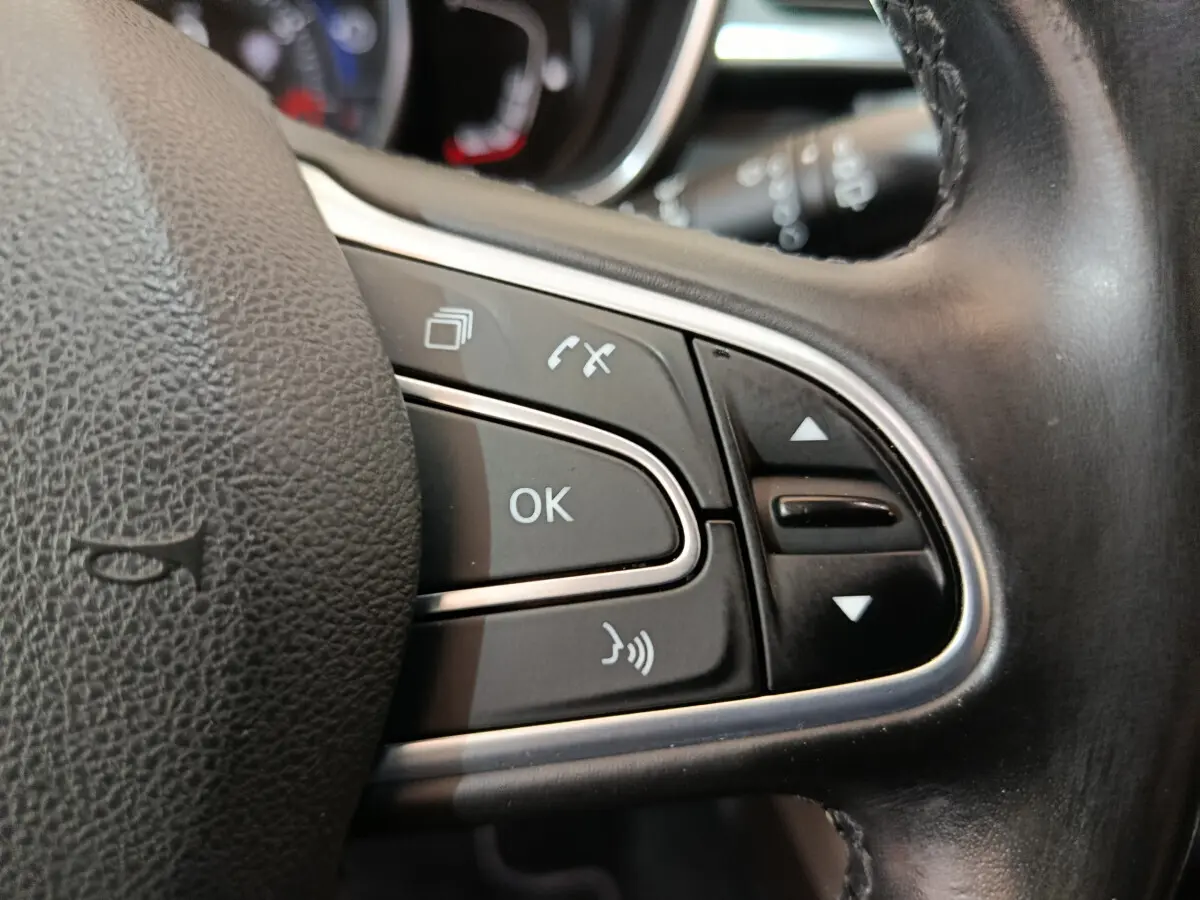 Gros plan sur les commandes multifonctions noires du volant cuir du Renault Kadjar Intens 2017.