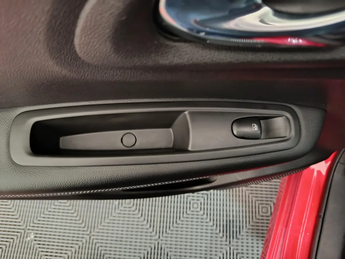 Poignée intérieure noire avec bouton de verrouillage sur la porte côté conducteur du Renault Kadjar rouge 2017.