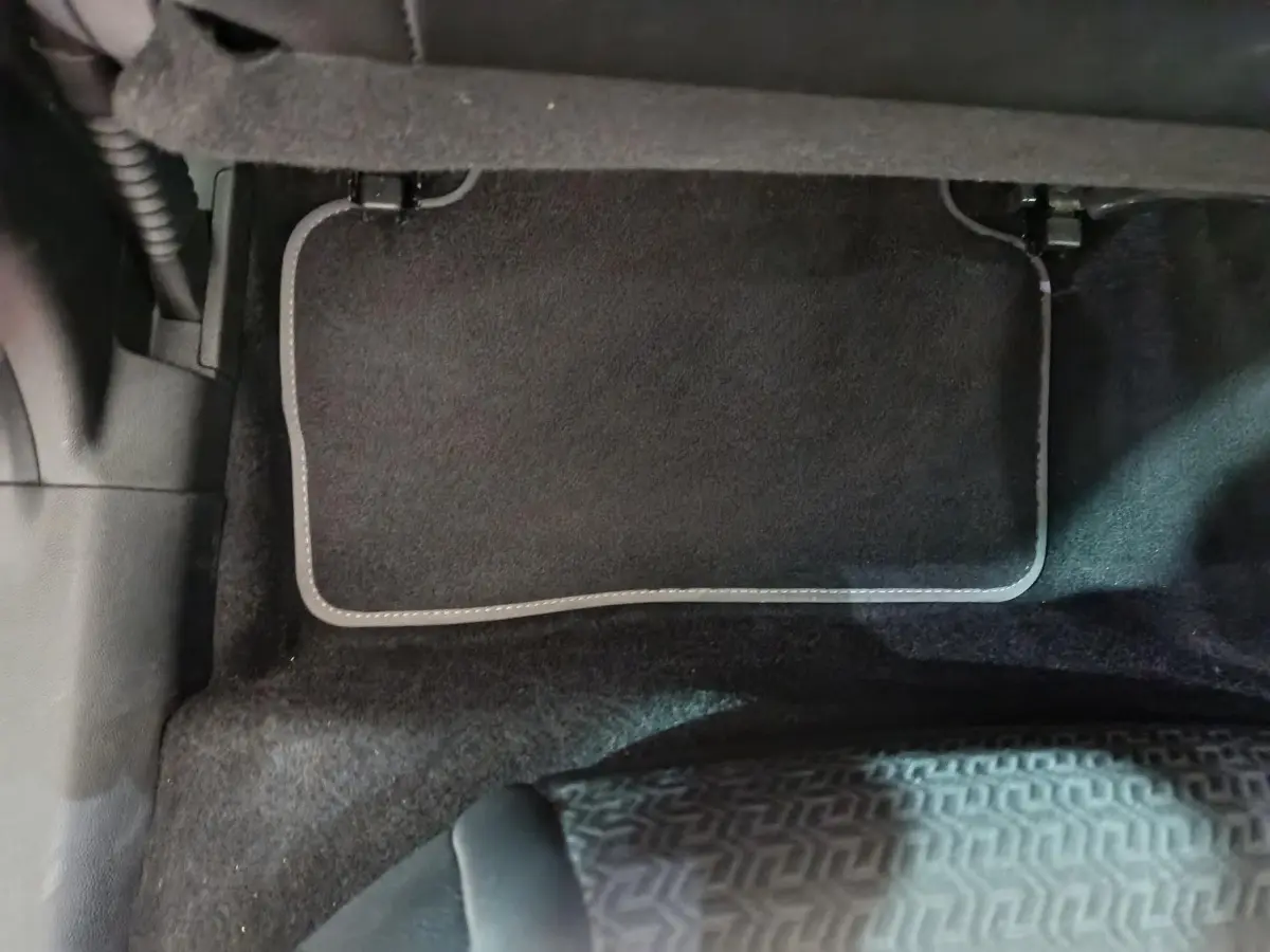 Tapis de sol noir côté conducteur du Renault Kadjar Intens rouge, vue rapprochée de l'intérieur au sol.