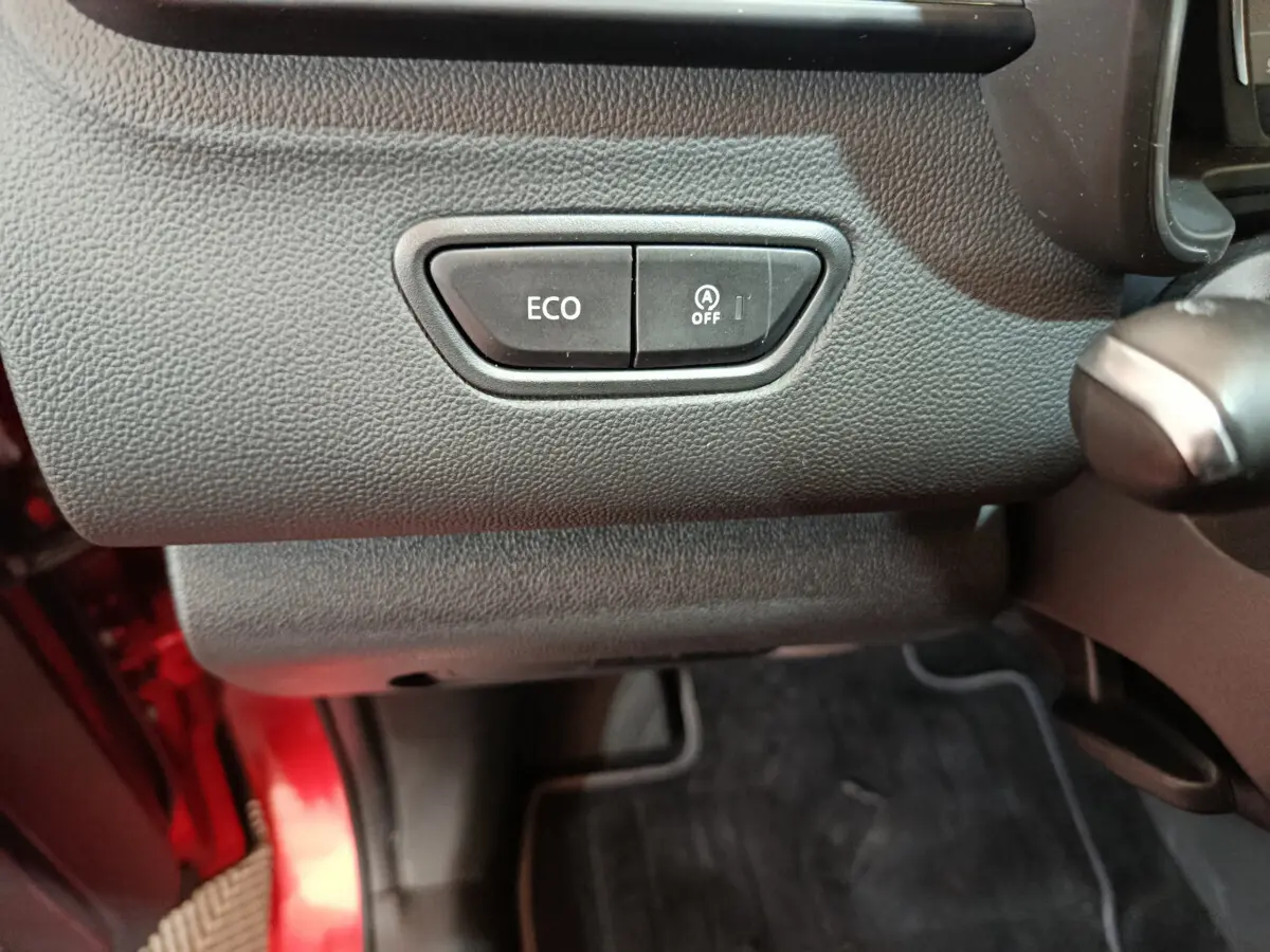 Gros plan sur les boutons ECO et arrêt du démarrage automatique dans l'habitacle du Renault Kadjar rouge 2017.