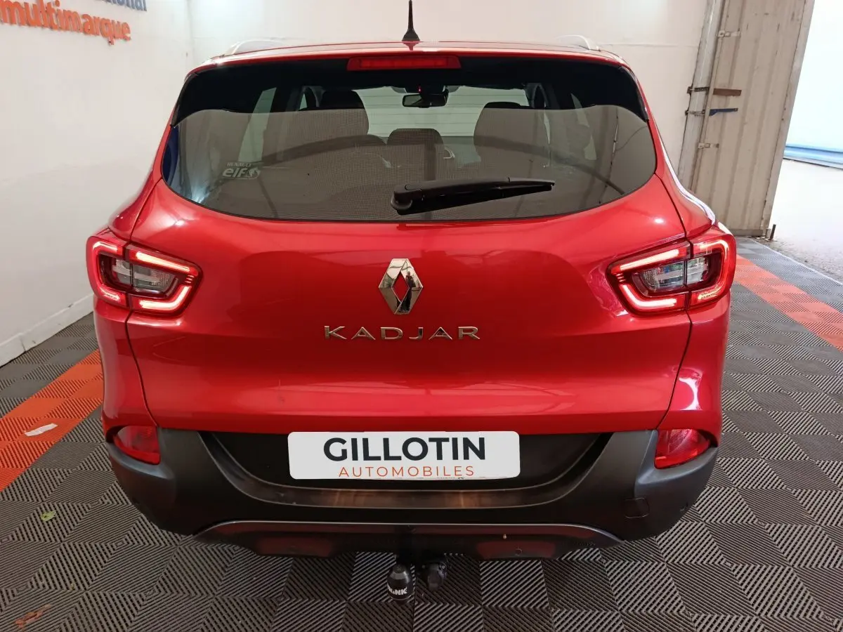 Vue arrière d'un Renault Kadjar rouge avec feux LED et attelage visible dans un garage.