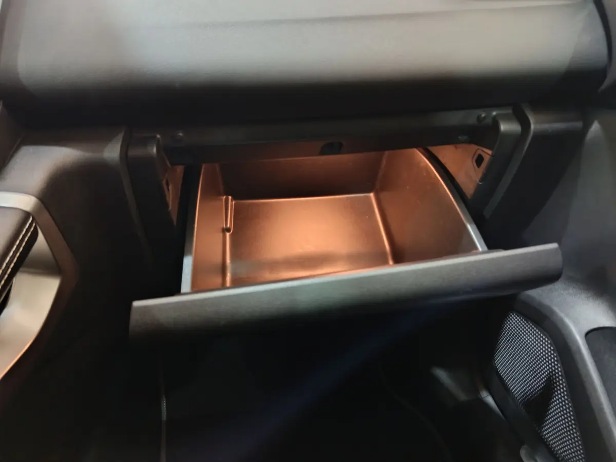 Gros plan sur la boîte à gants ouverte côté passager du Renault Kadjar Intens rouge de 2017.