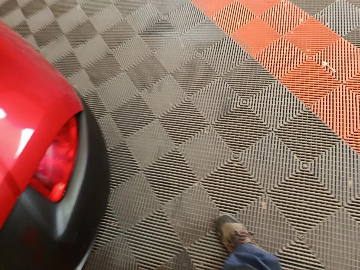 Gros plan sur le coin arrière gauche rouge du Renault Kadjar Intens avec feu arrière et partie du pare-chocs noir.