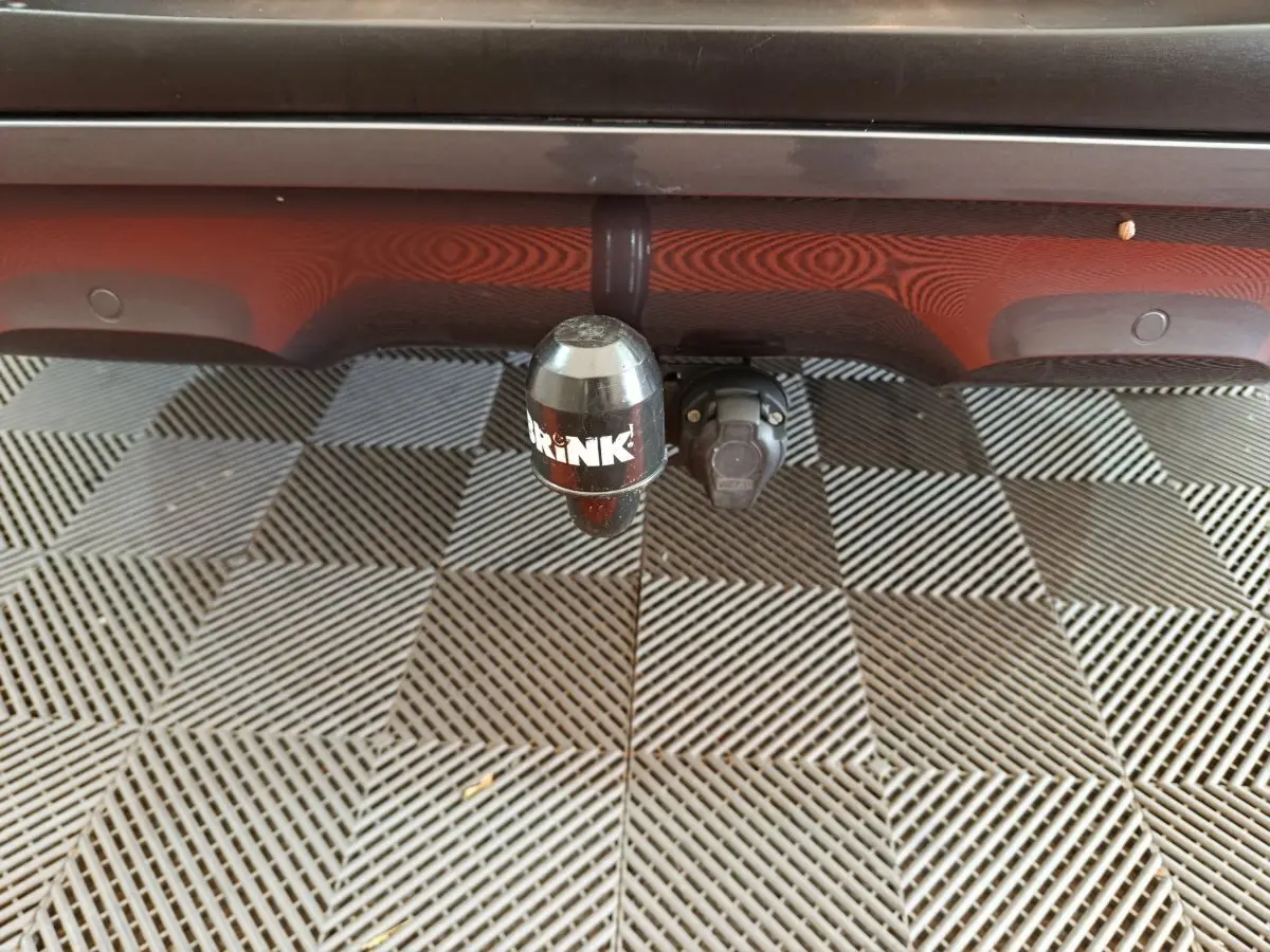 Gros plan sur l'attelage de remorque noir fixé sous le pare-chocs arrière rouge du Renault Kadjar Intens 2017.