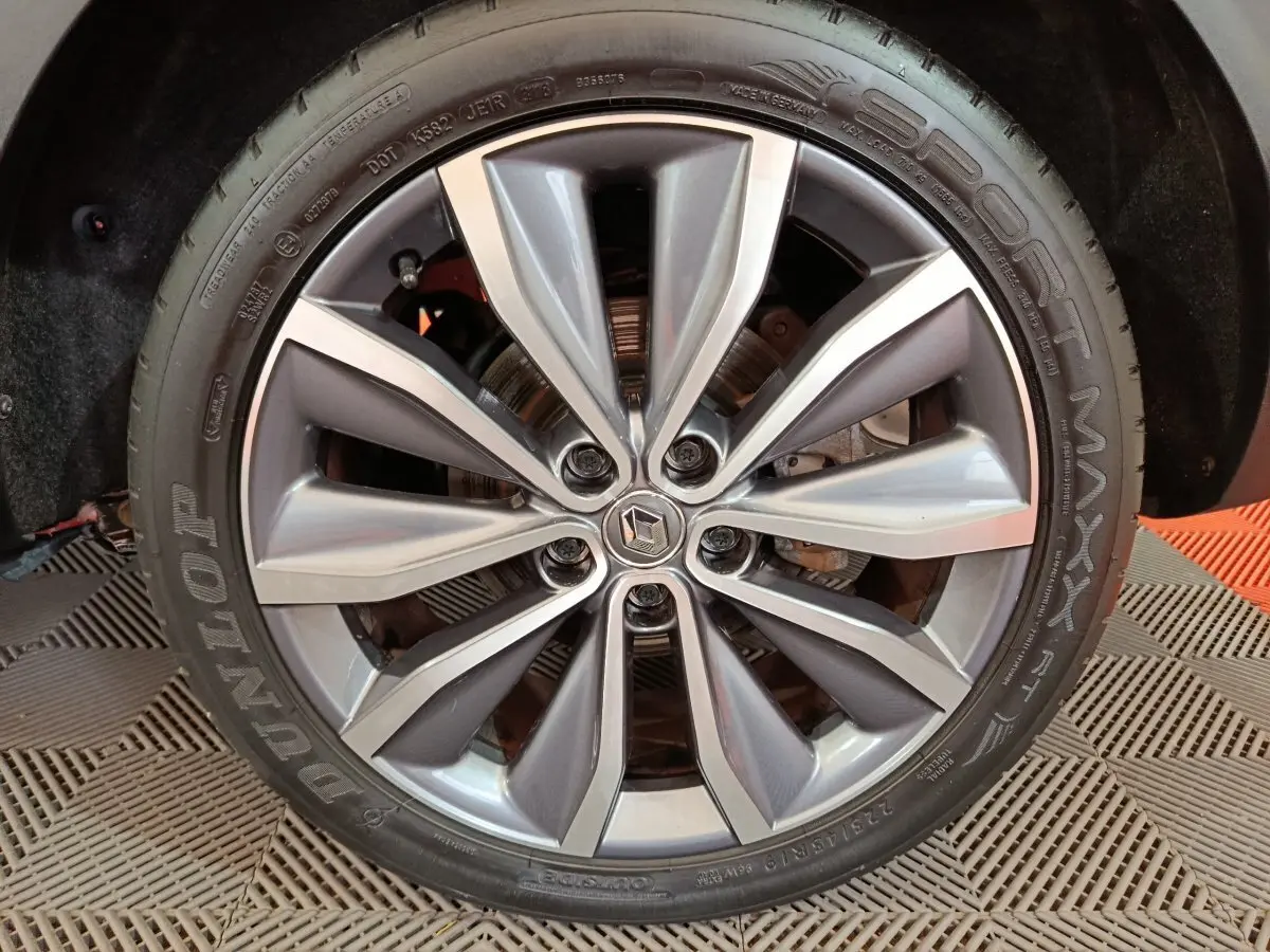 Gros plan sur la jante alliage argentée avec logo Renault du Renault Kadjar Intens rouge de 2017.