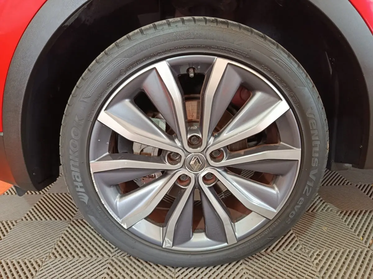 Gros plan sur la roue avant droite du Renault Kadjar rouge, mettant en valeur la jante alliage et le logo central.