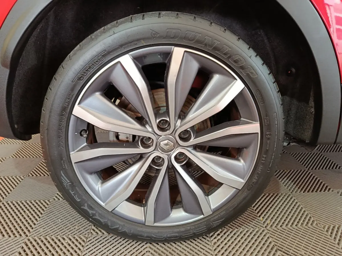 Gros plan sur la roue avant droite du Renault Kadjar rouge, mettant en valeur la jante alliage et le pneu Dunlop.