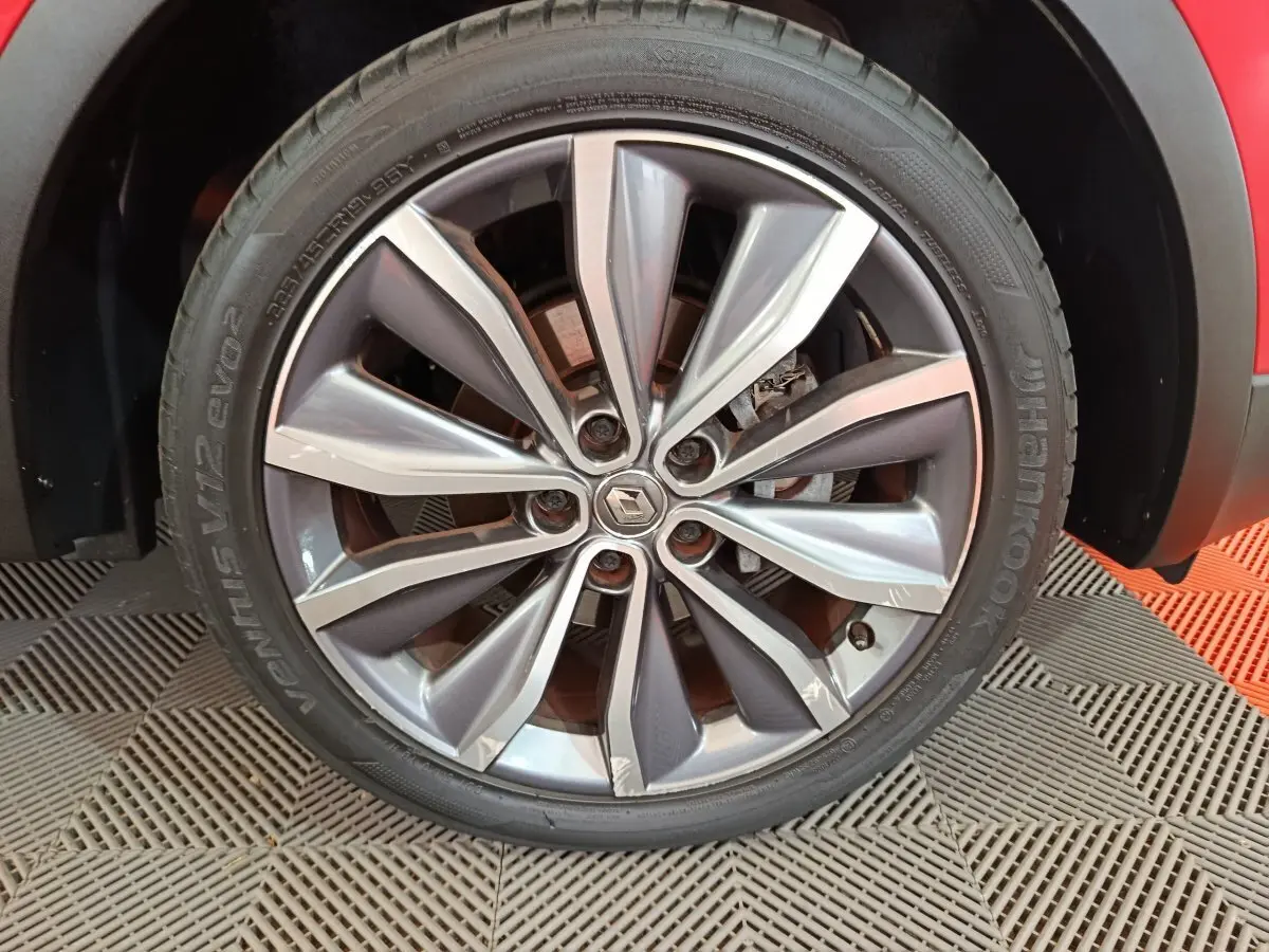 Gros plan sur la roue avant droite du Renault Kadjar rouge, avec jante alliage au design moderne et logo central Renault.