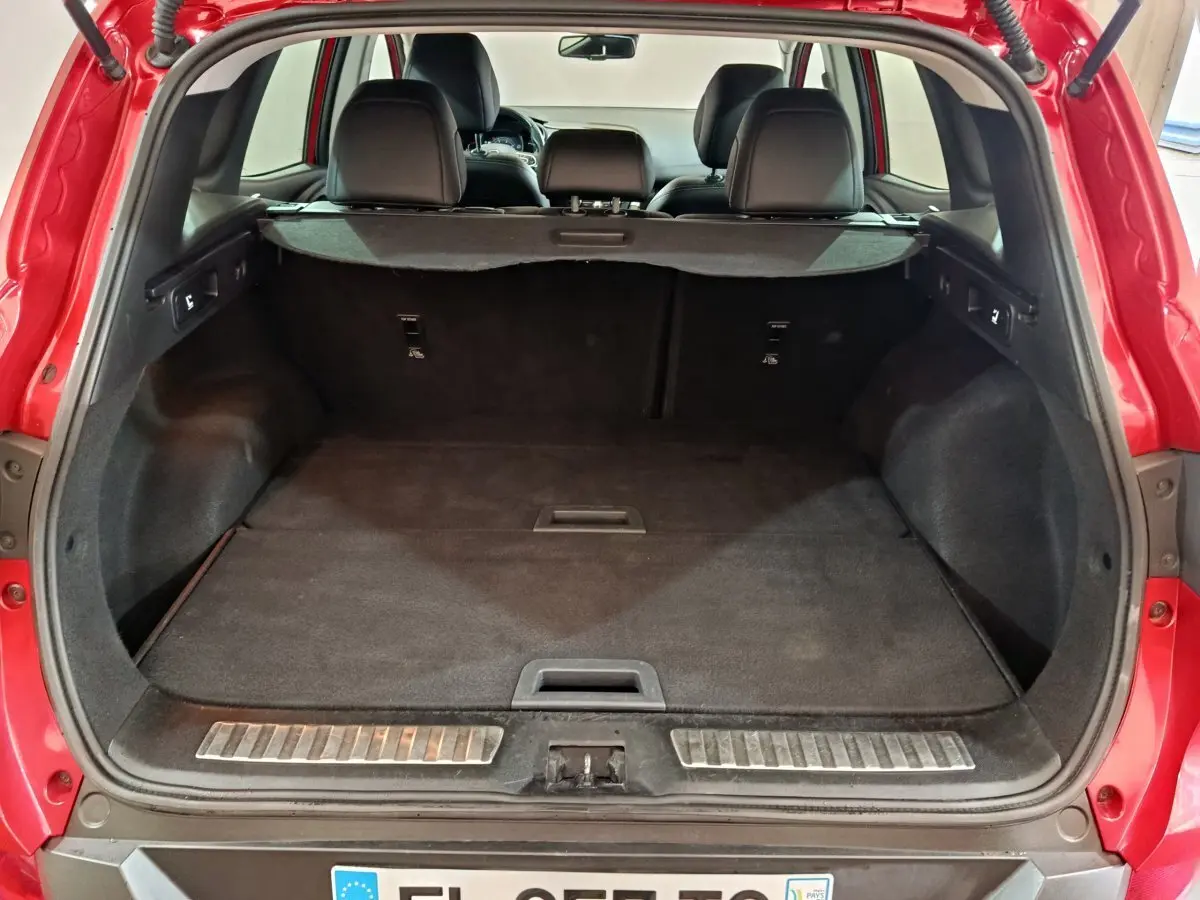 Vue arrière du coffre spacieux d'un Renault Kadjar Intens rouge de 2017 avec banquette noire rabattue et tablette de séparation.