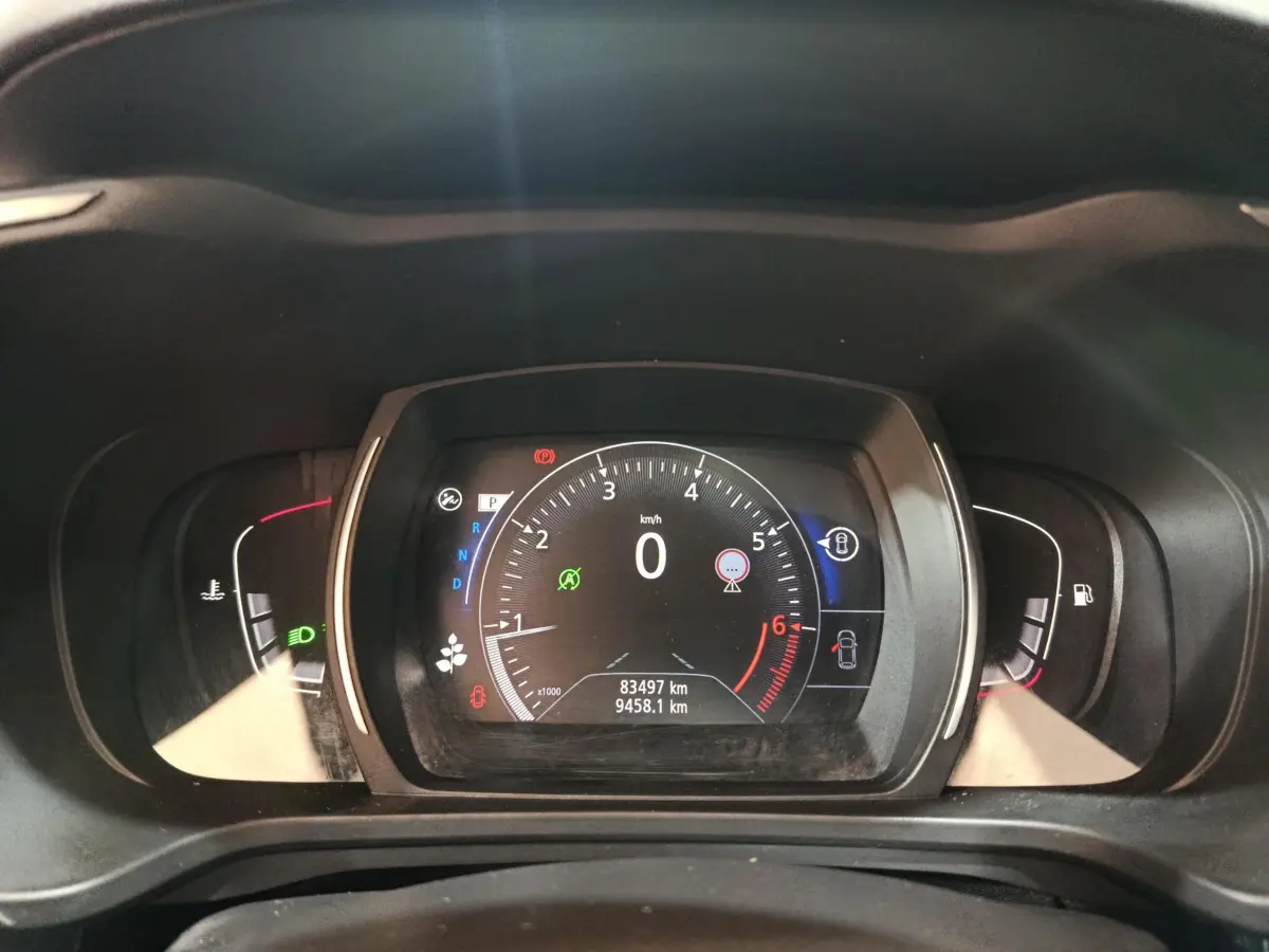 Vue rapprochée du tableau de bord numérique du Renault Kadjar rouge, affichant la vitesse à zéro et les indicateurs actifs.