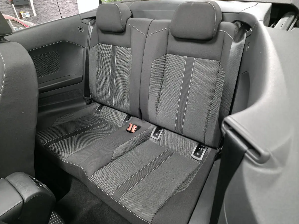 Banquette arrière en tissu noir avec appuis-tête du Volkswagen T-Roc Cabriolet gris, vue intérieure rapprochée.