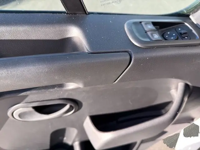 Détail de la porte intérieure côté conducteur du Renault Master blanc 2023, avec commandes de vitres et rétroviseurs.
