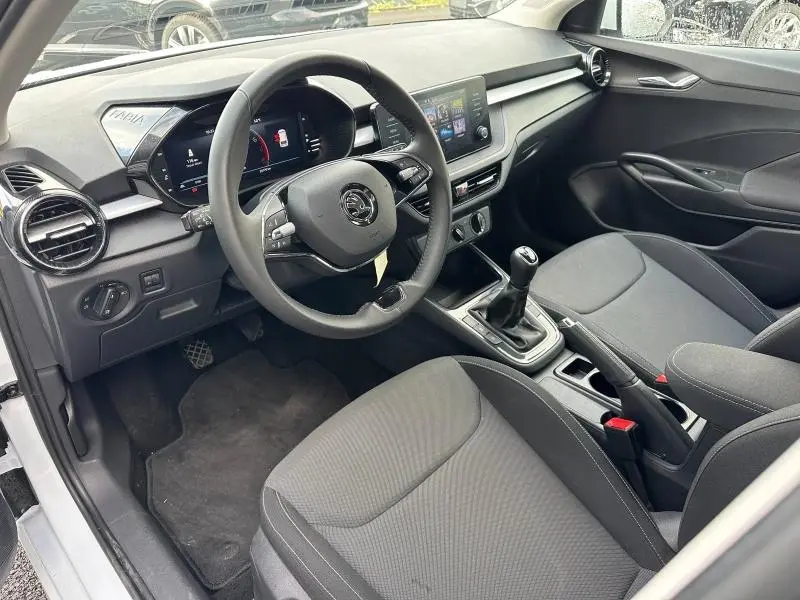 Intérieur avant droit d'une Skoda Fabia 2024 avec volant cuir multifonction et console centrale manuelle noire.