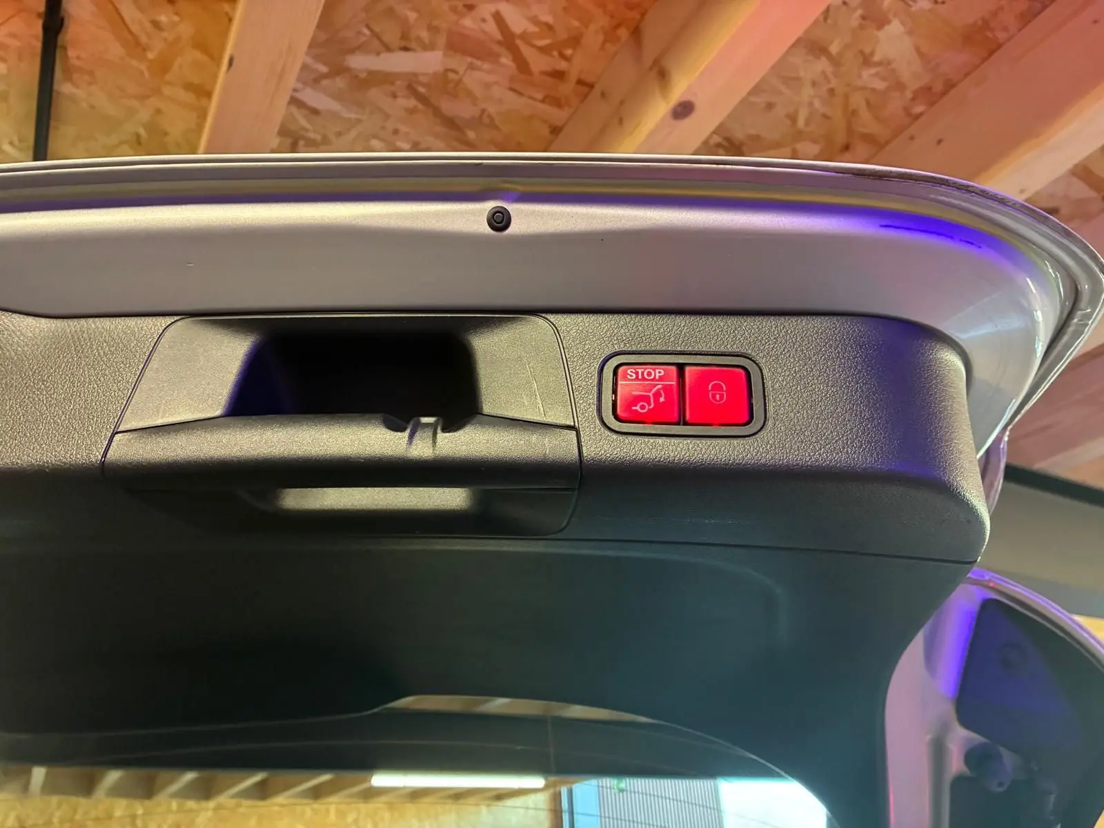 Bouton rouge d'ouverture et fermeture électrique du hayon sur le bord intérieur du coffre d'une Mercedes Classe B gris 2019.
