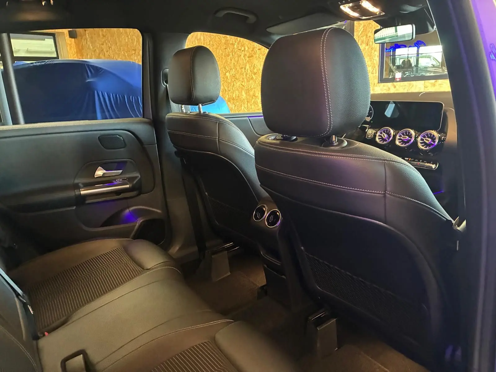 Vue intérieure arrière droite de la Mercedes Classe B 200D Progressive Line 2019 avec sièges tissu gris noir et aérateurs centraux.