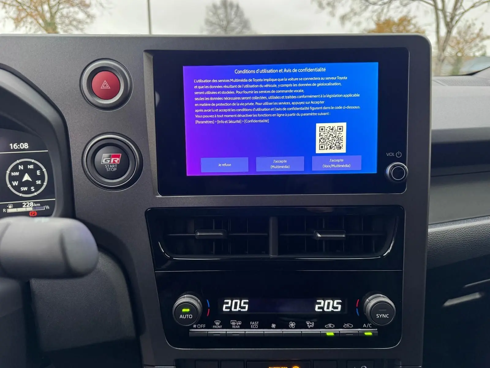 Vue intérieure centrée sur l’écran tactile et la console de la Toyota Yaris GR Pack Techno, avec commandes climatisation digitales.