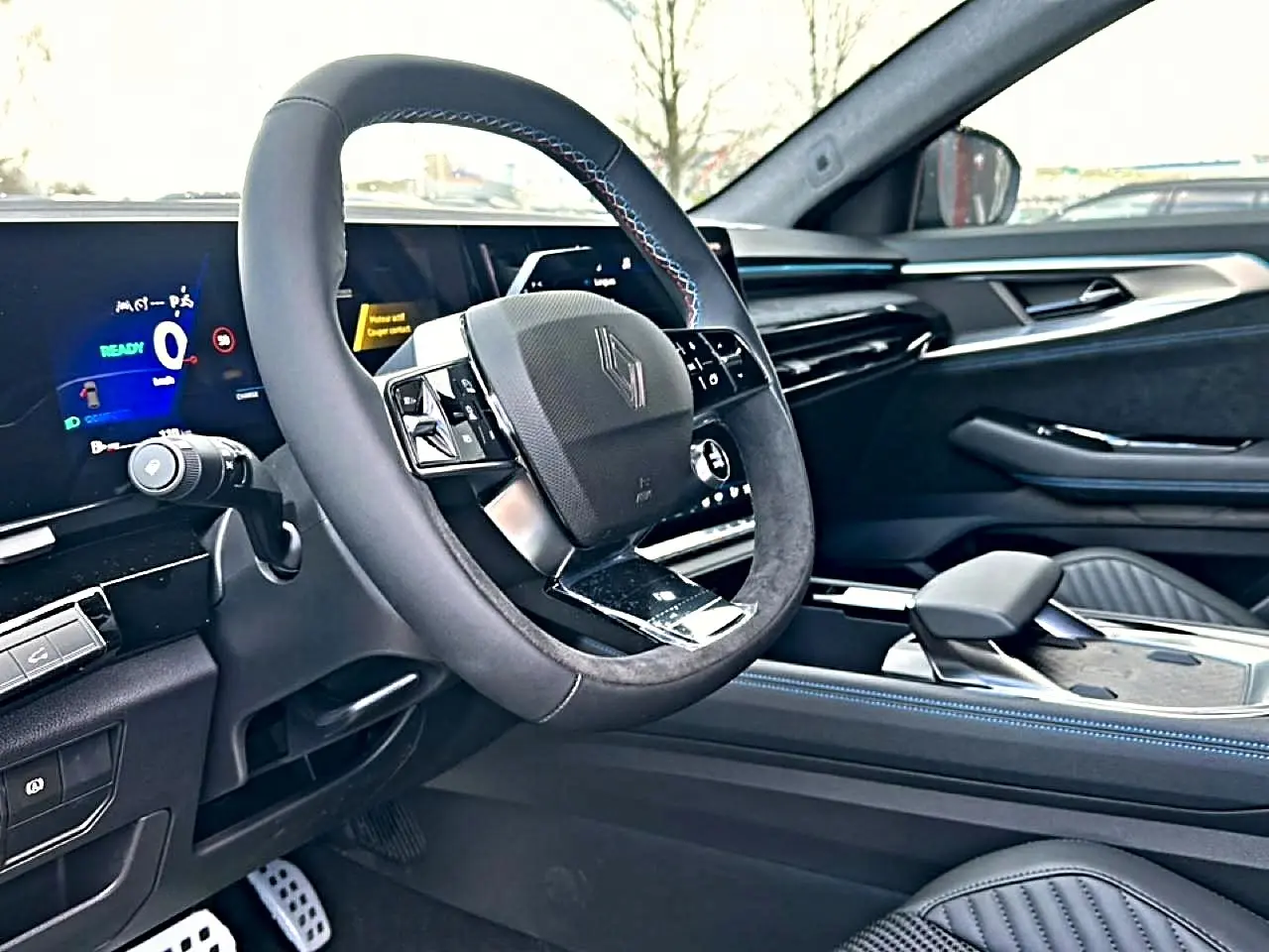 Intérieur avant droit du Renault Austral 2026, volant multifonction noir avec surpiqûres bleues et tableau de bord digital.