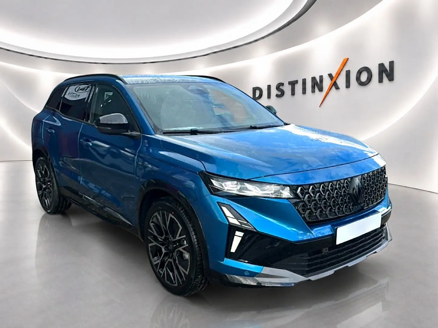 Renault Austral bleu outremer en 3/4 avant droit, avec calandre noire et jantes alliage noires distinctives.