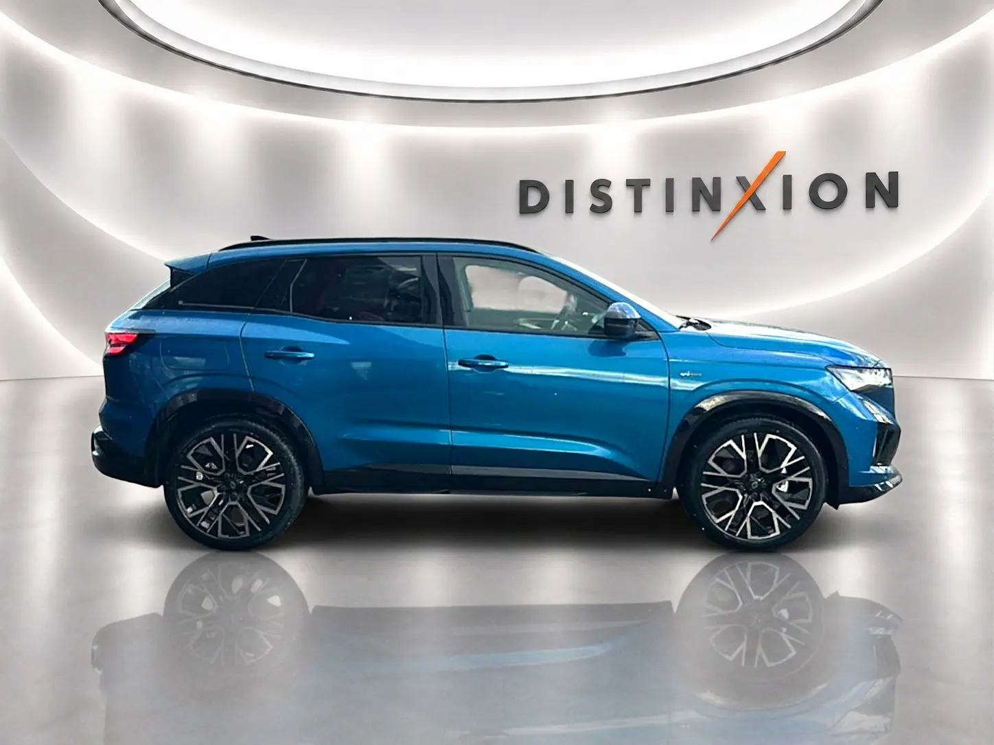 Profil droit du Renault Austral bleu outremer 2026 avec jantes alu noires et toit noir, sur fond lumineux intérieur.