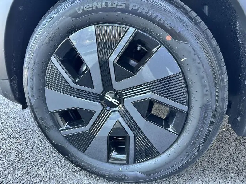 Gros plan sur la jante noire au design moderne du côté avant droit d'une Dacia Sandero beige Safari 2025.